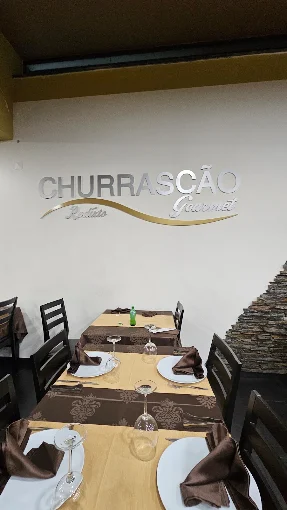 Mesas junto ao logótipo do Churrascão Gourmet